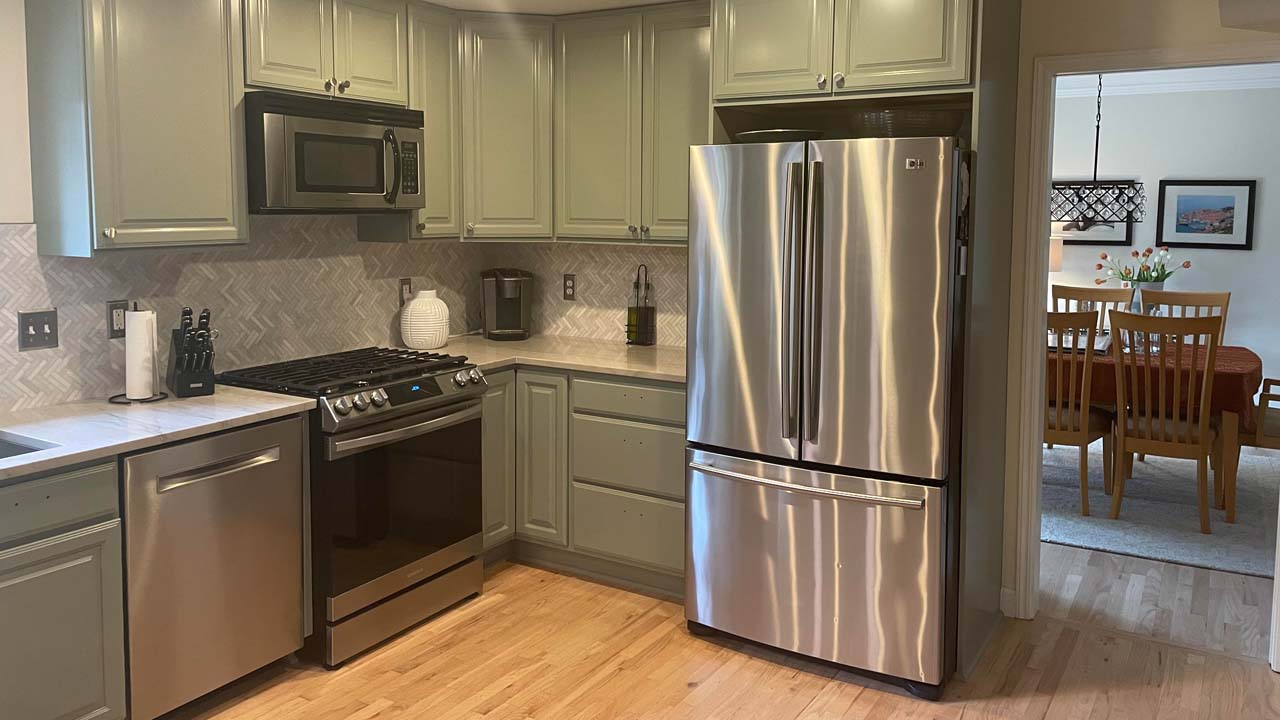 Beautiful wood floors, ashiny fridge and a new paint job on these cabinets make this kichen look fabulous.