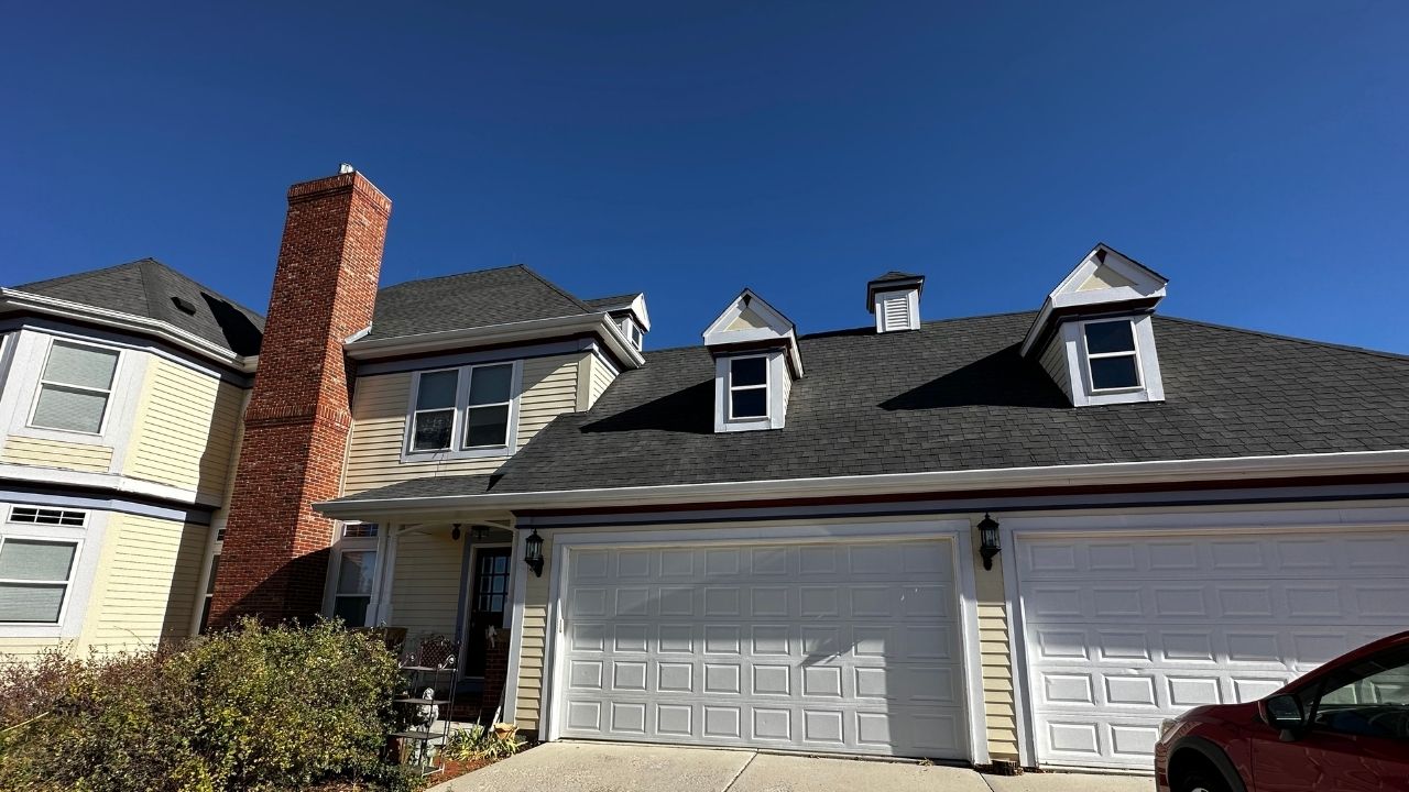 A street view under a vibrant blue sky features a beautifully painted home by Elk Horn Painting. The white - beige exterior shines with a fresh, professional finish.