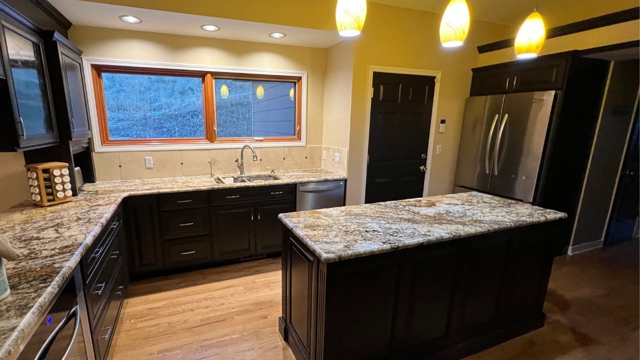 A modern kitchen featuring newly painted cabinets in a sleek, fresh dark brown finish by Elk Horn Painting.