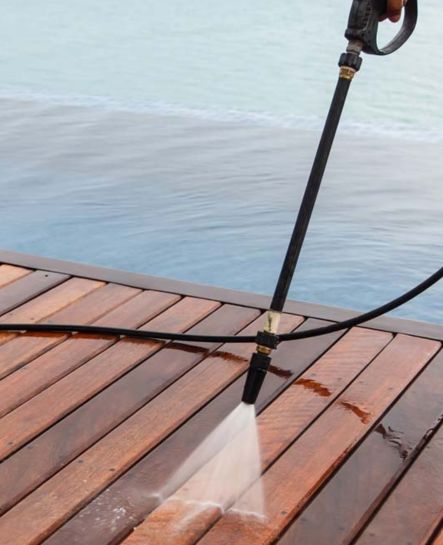A detailed view of a deck being pressure washed by Elk Horn Painting – Denver, revealing the wood's refreshed natural tone.